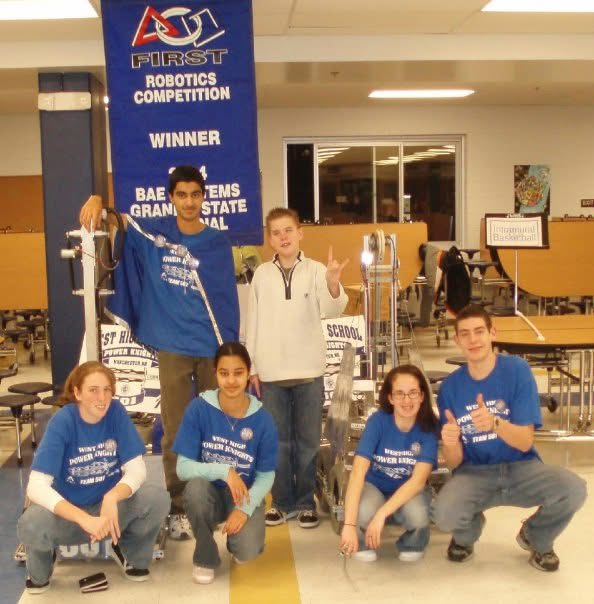 April with her FIRST Robotics team under a Granite State Regional winner banner.