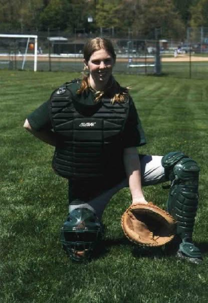 April in full catcher's gear on a softball field.