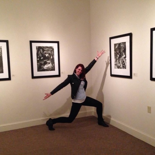 April in a gallery beside four framed lithographs