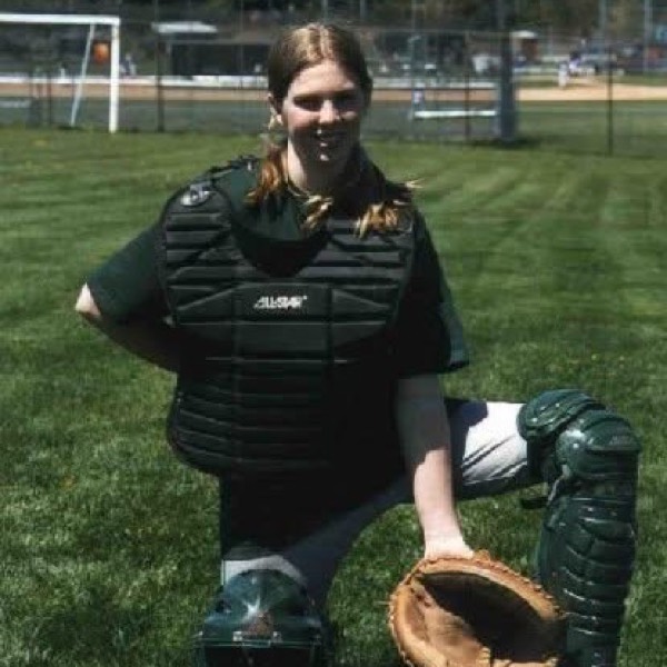April in catcher's gear on a high school softball field