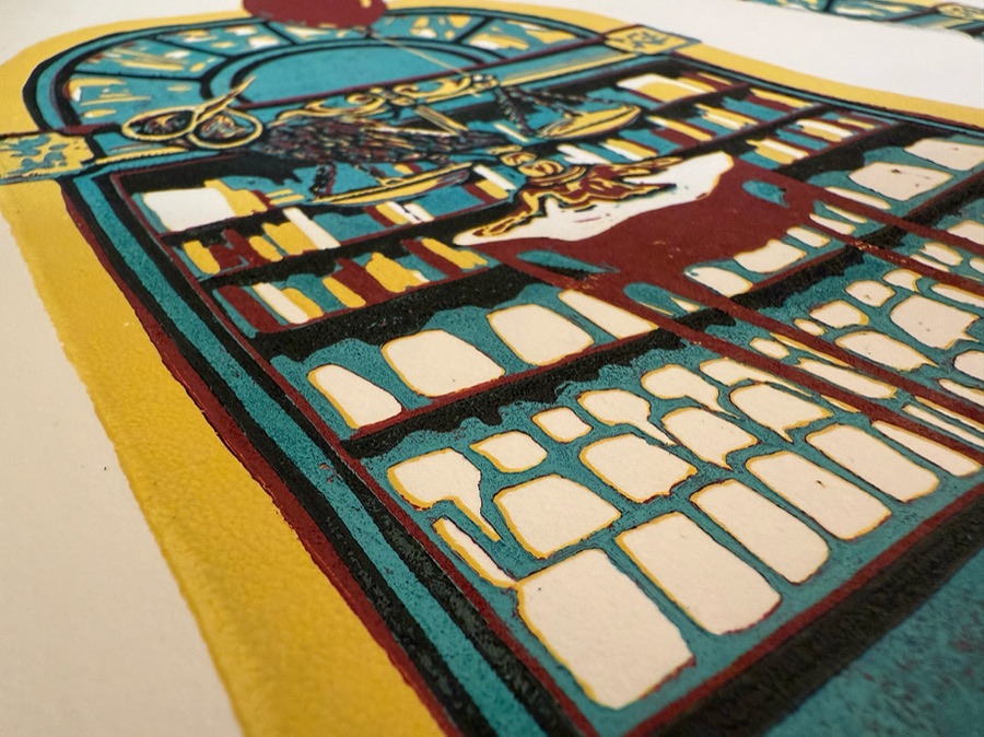Sunbird Saboteur, a reductive linocut in teal, red and yellow, shown in raking light