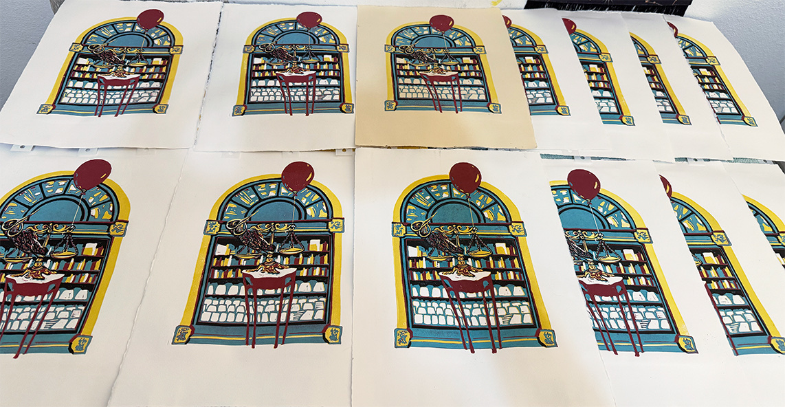 A dozen prints of Sunbird Saboteur laid out to dry, one full edition run.